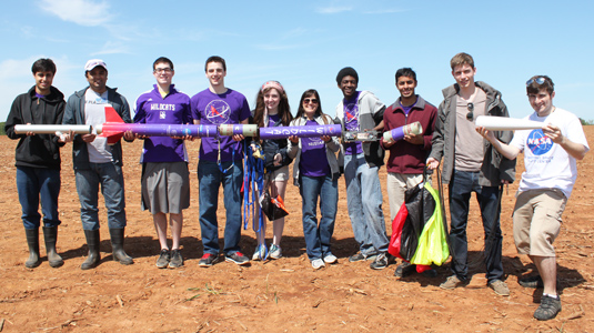 Members of NUSTARS show off pieces of their nine-foot, homemade rocket at NASA's University Student Launch.