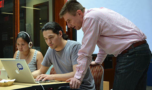 Professor Diego Klabjan (right) observes students participate in the MSiA program's first Hackathon.