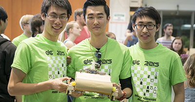 Members of Team Veggie Bot hold their winning robot. Left to right: Sean Ye, Simon Zhao, and Eric Hao.