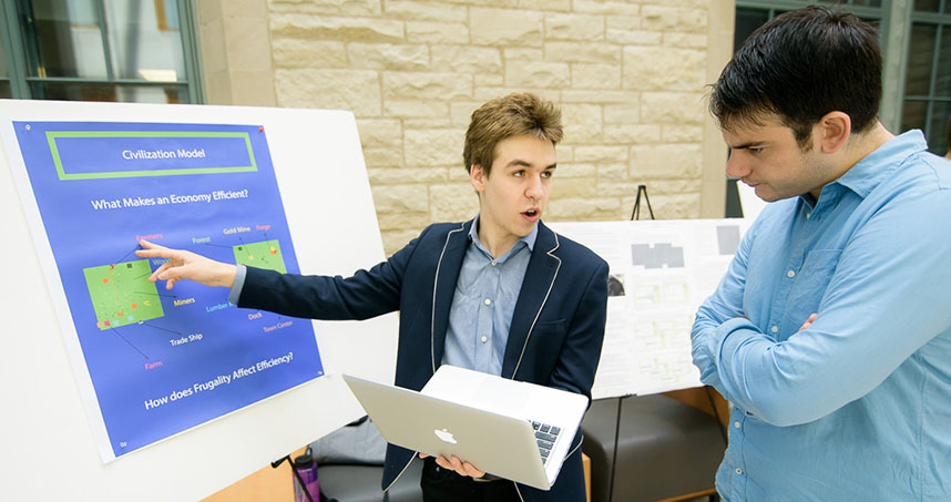 Sophomore Gabriel Pezanoski-Cohen explains his model to a visitor at the poster session.