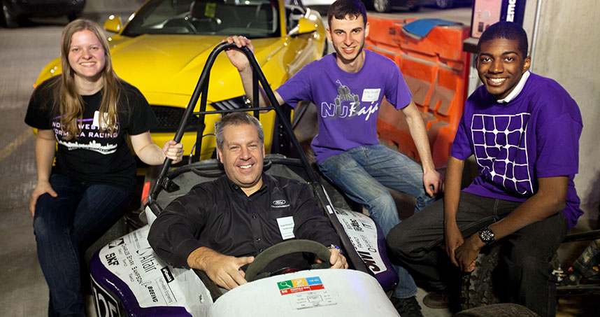 Ford's Joseph Hinrichs sits in the students' Formula racing car.