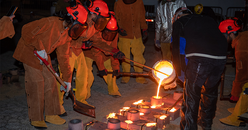 Design 395-64 students pour iron into molds on May 31 in the Ryan Field parking lot. Credit: Rob Hart