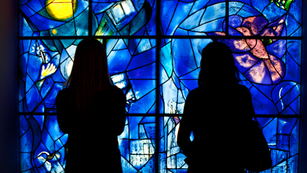 Silhouette of viewers at the blue AIC Chagall window installation