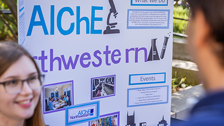 Student with AIChE poster at fair