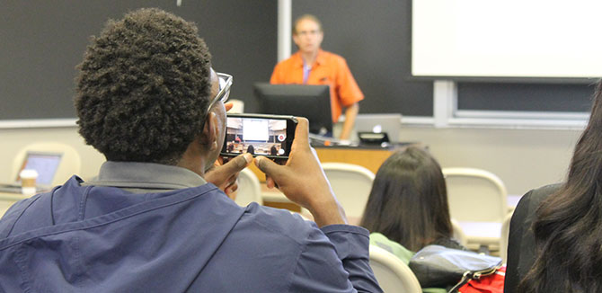 A student records a lecture delivered by Daniel Jimenez (TAMU)