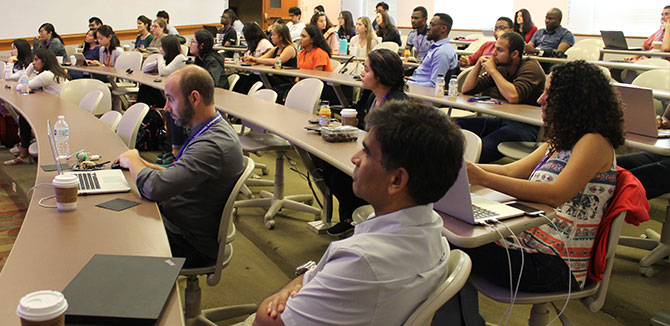 Audience members attentively listen to a speaker..