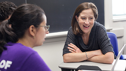Sara Sood speaking with students in front of a laptop