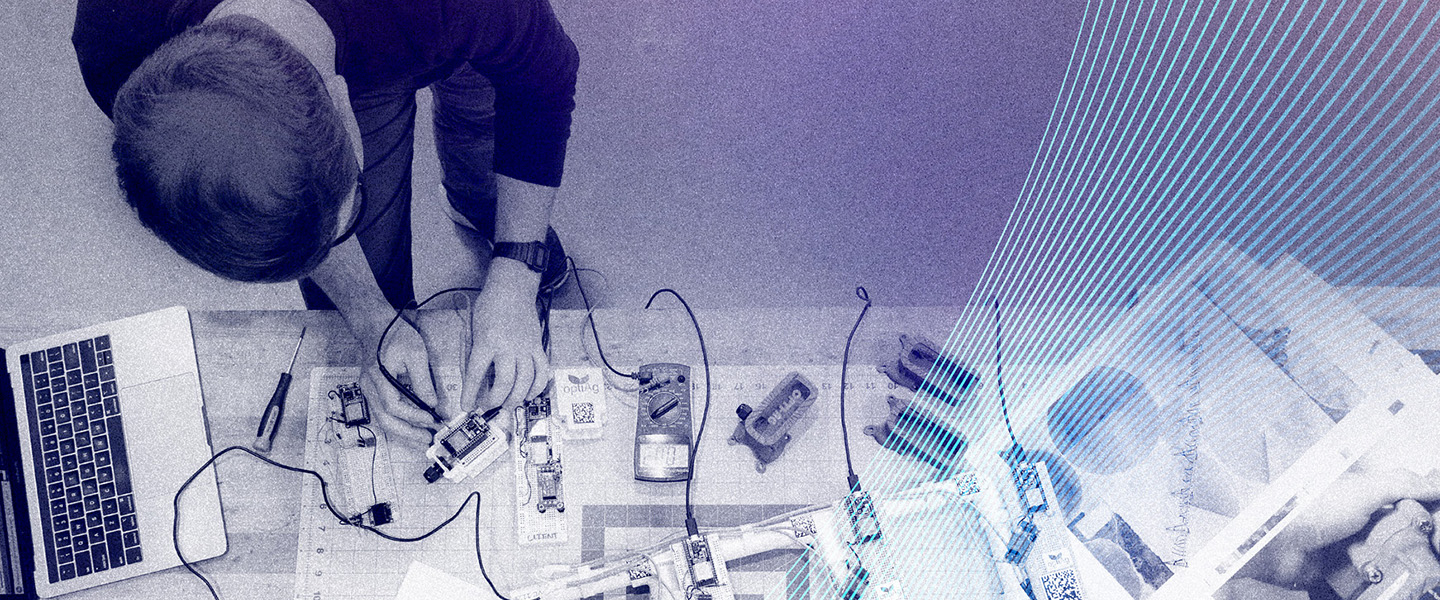 A birds eye view of a graduate student configuring wires on a device.