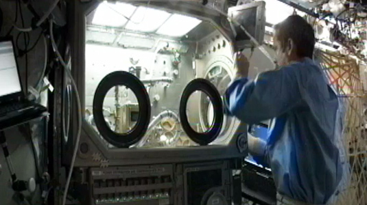 Astronaut Chris Hadfield of the Canadian Space Agency installs McCormick School of Engineering furnaces in the Microgravity Glove Box at the International Space Station.