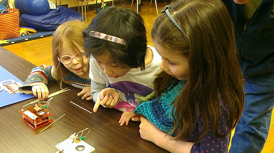 Kids react to an experiment in which cockroach legs are electrically stimulated at the 2012 Brain Fair.