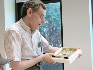 Professor Allen Taflove presents Brodwin with a gift of an engraved clock.