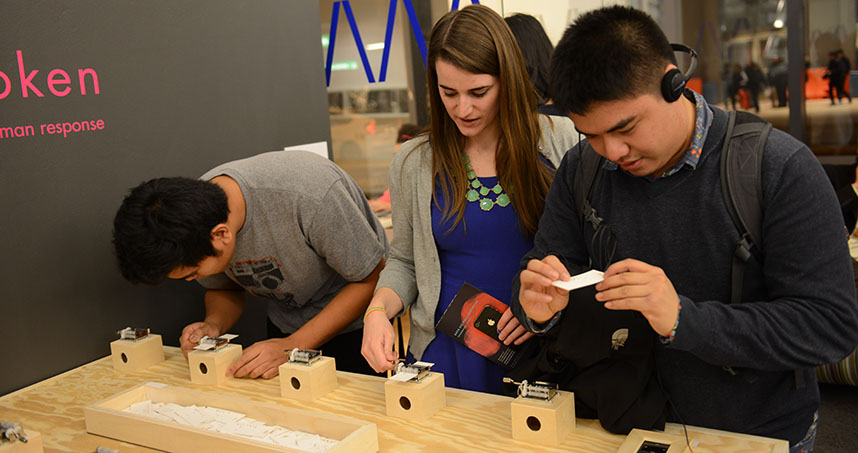 Northwestern's Mary Beth O'Neil (middle) explains her group's project Un*spoken to visitors.