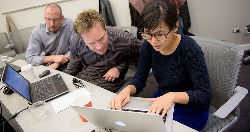 Teradata's Greg Bethardy and Russ Ratshin help MSiA student Jung-Hee Oh with her Hackathon project.