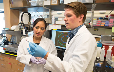 Senior Nick Geisendorfer and his advisor Ramille Shah inspect a fabricated solid oxide fuel cell created using 3-D printing technology. Photo by Jim Prisching.