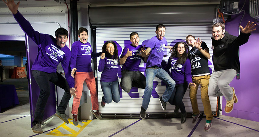 Excited about the new space, members of the Baja team jump for joy.