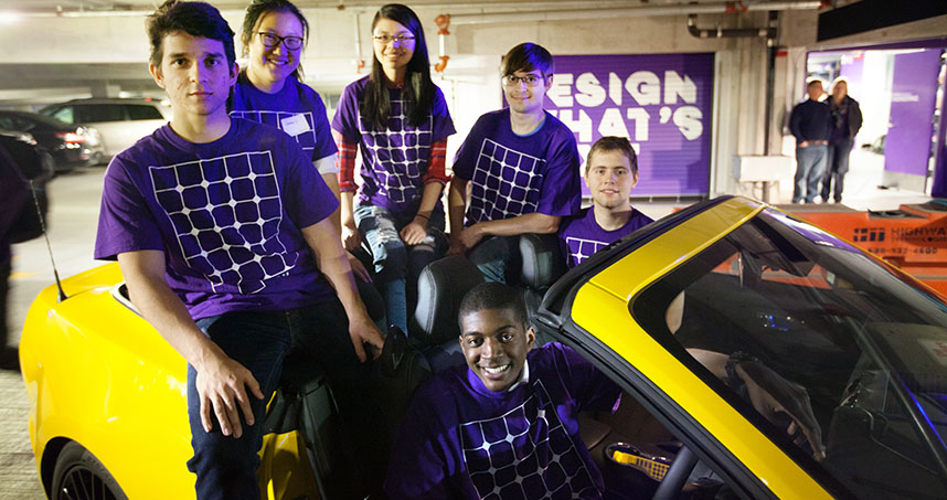 Members of NUSolar sit in a yellow Mustang that Ford representatives brought to the event.