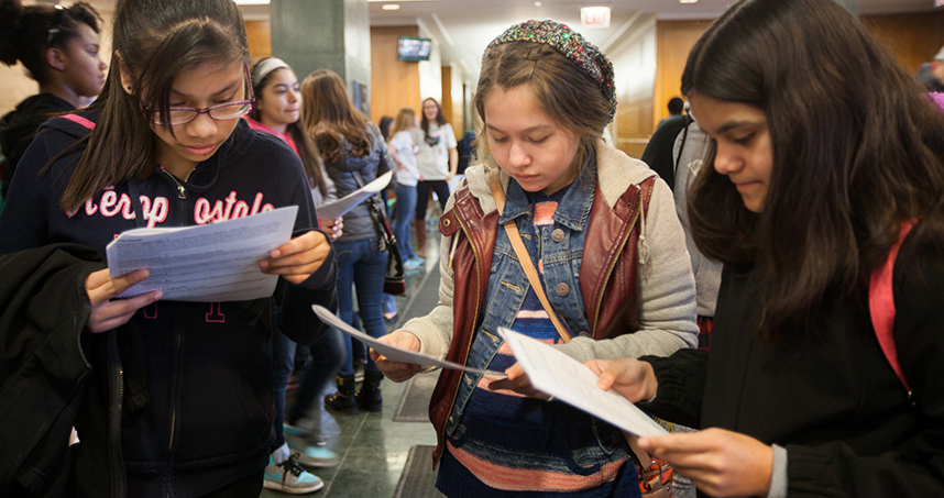 Participants look at the day's schedule, filled with hands-on experiments, lab tours, and discussions.
