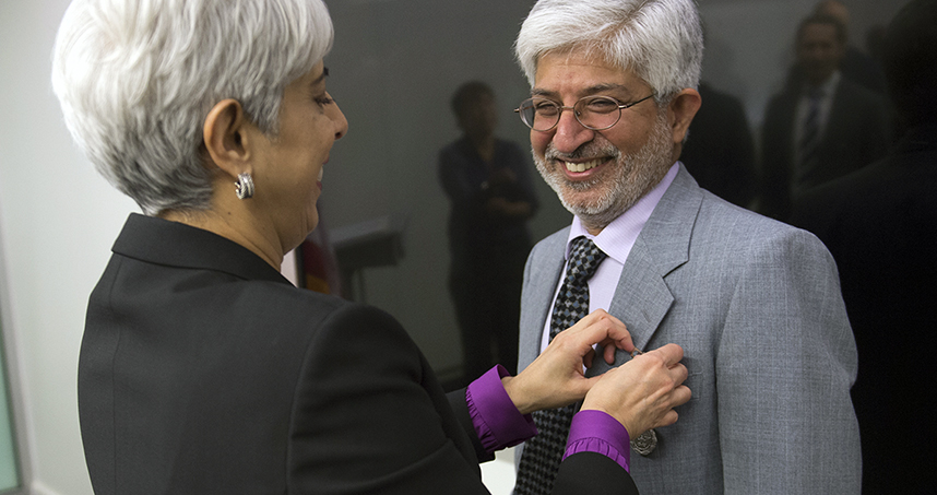 Former DARPA director Arati Prabhakar pins the Secretary of Defense Medal to Professor Prem Kumar's jacket.