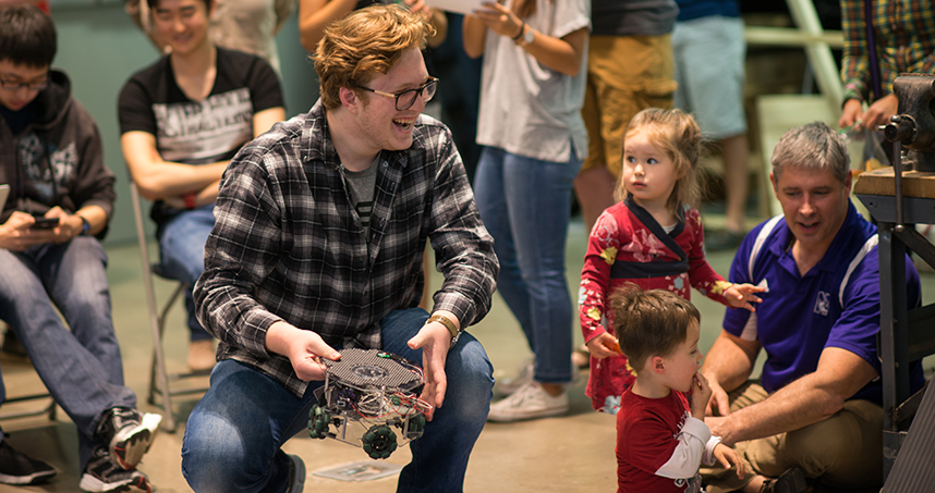 A student participant laughs as he watches the competition.