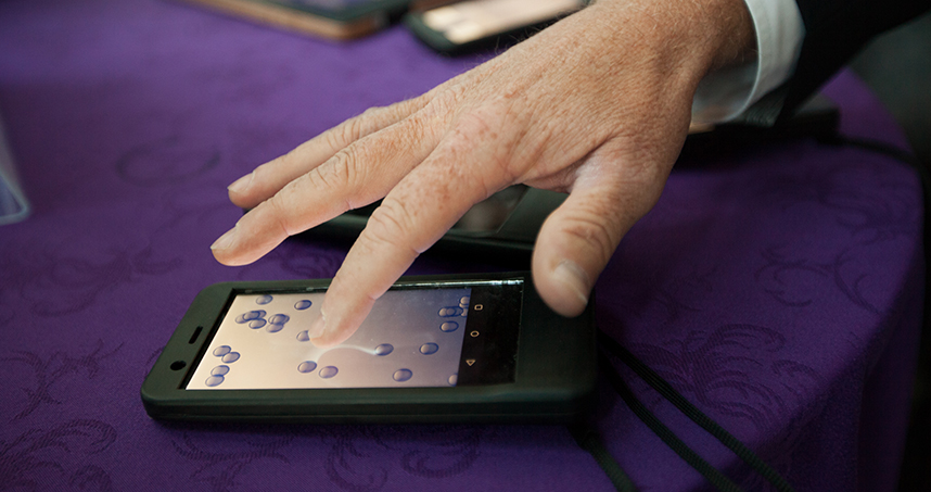 A guest at the demo session tests Tanvas's T-Pad phone, which uses ultrasonic signals to give a flat screen texture