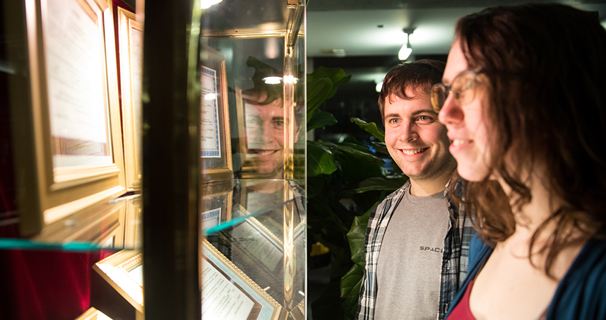 Visitors examine text-based installation "Fake It Until You Make It."