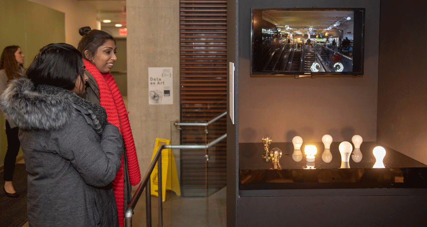 Visitors interact with "Light -- Sound," in which a screen interprets light from the room into sound.