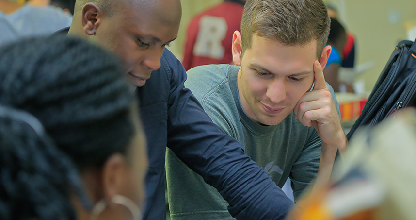 PhD student Luke Prestowitz works with team member during a JUAMI lab activity.