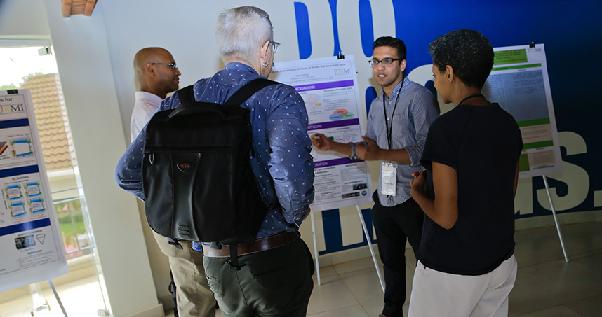 Sheel Sanghvi, a fifth year PhD student, discusses research with JUAMI faculty at a poster session.