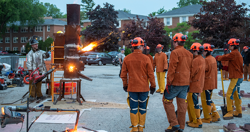 Northwestern students watch sparks fly from a historical furnace in the Ryan Field parking lot. Credit: Rob Hart