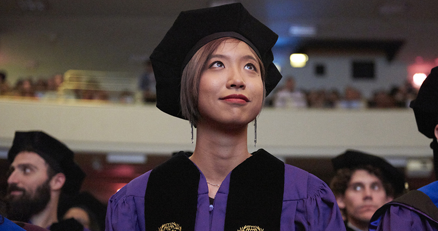 A PhD graduate watches the hooding ceremony in Ryan Auditorium on June 21. Credit: Joel Wintermantle