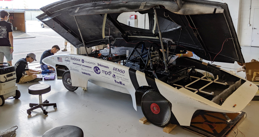 Students work on the solar car, which passed all mechanical, electrical, and battery inspections at the race. 