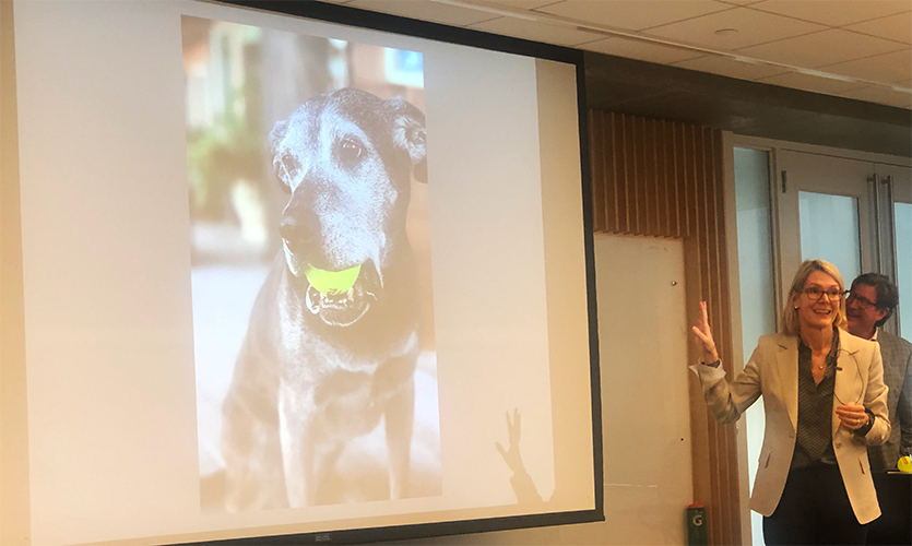 With an image of Annabelle on display, Karen May speaks at the event. Joseph Holtgreive is seen in the background.