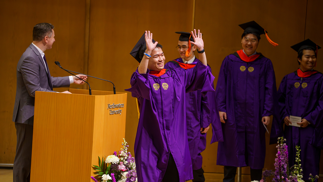A graduate walks across the Pick-Staiger Concert Hall stage.