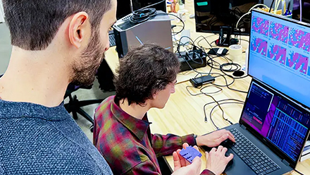 Student and professor in front of a computer screen