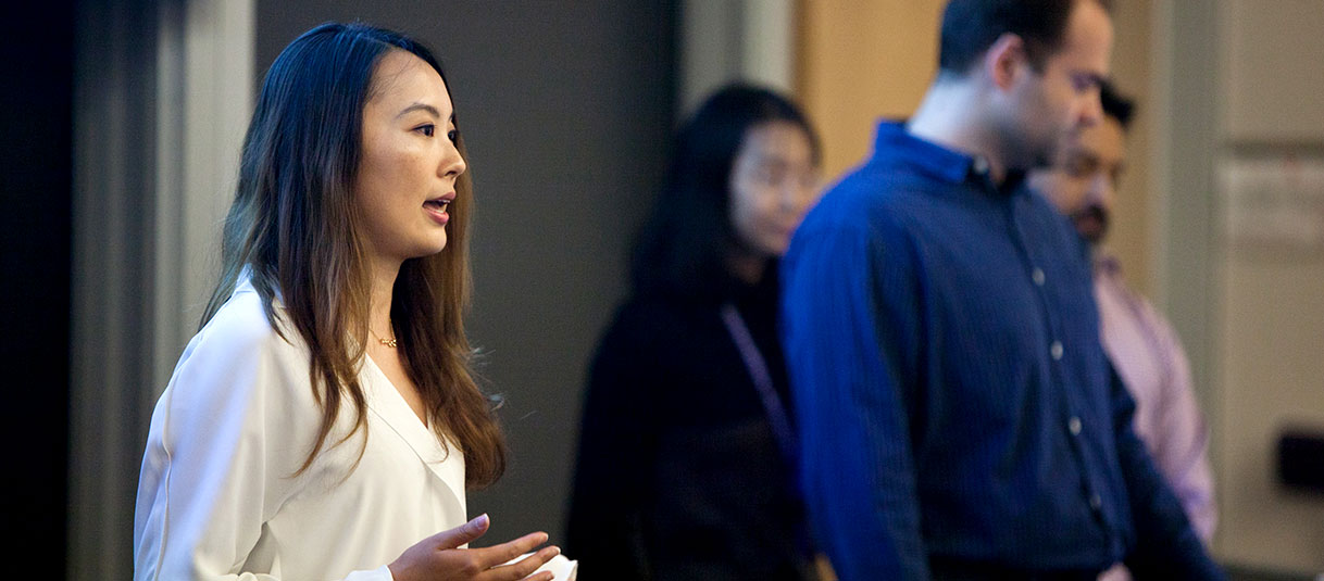 MSIT student speaking in front of a classroom, with other students in the background