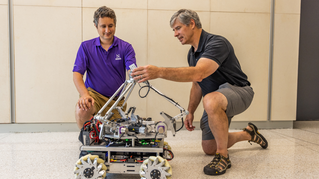 Matthew Elwin and Kevin Lynch adjust the mocobot's gimbal wrist.