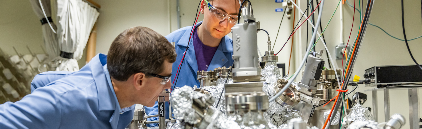 Hersam and a student working on large equipment