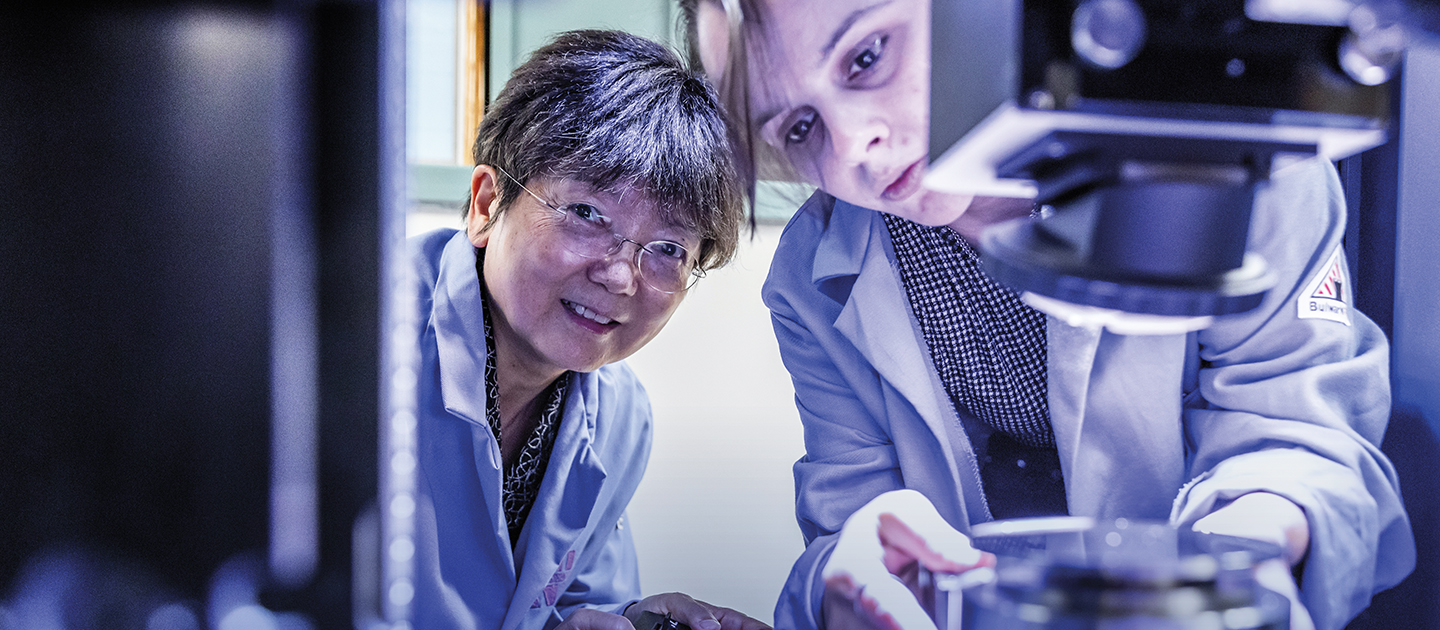 ane Wang working with student in lab
