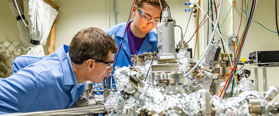 Professor Hersam with student in lab studying a device