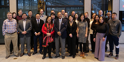 Group of 25 people standing and smiling