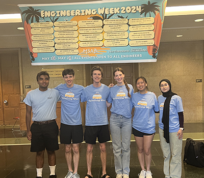 Students posing in front of an Engineering Week banner