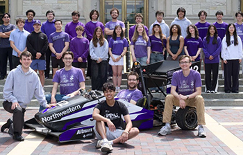 Group photo of racing team with car