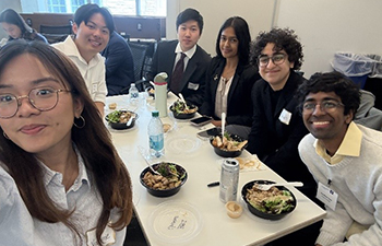 Group photo of six students gathered for a meal