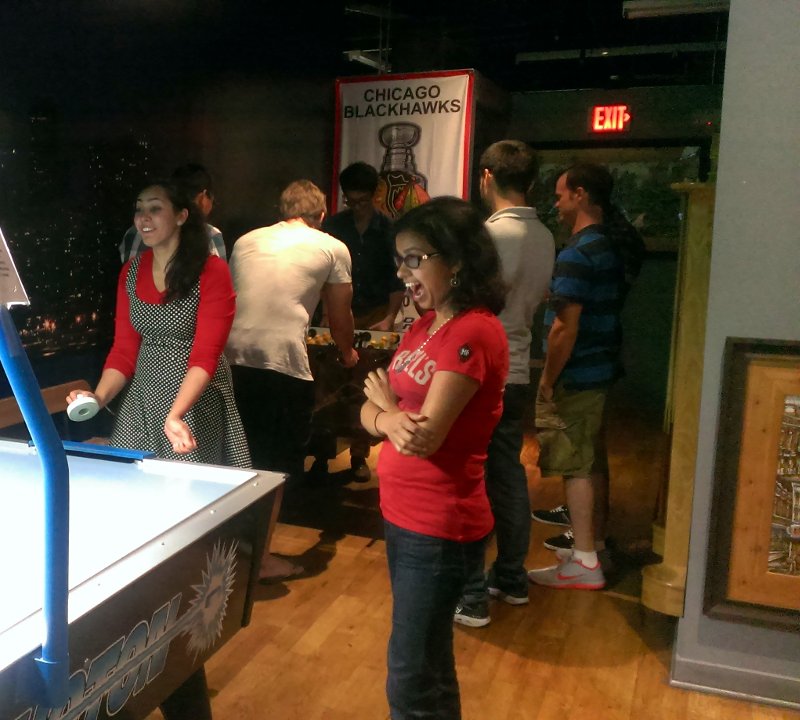 MSR students playing air hockey and foosball at the post-hackathon social gathering.